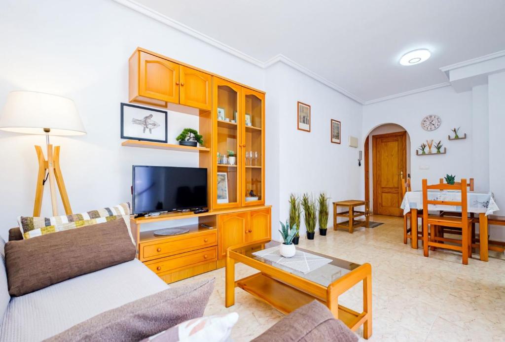 een woonkamer met een bank en een tv bij Vallejos ID58 in Torrevieja