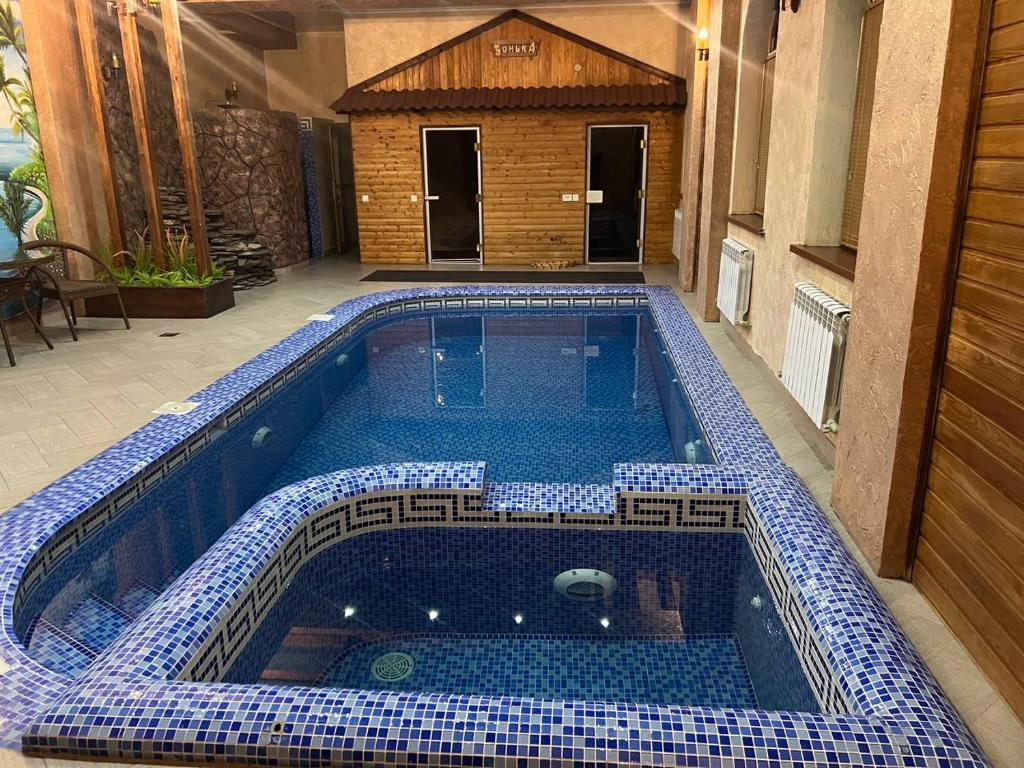 a swimming pool with a blue and white tiles on it at STATUS in Shymkent
