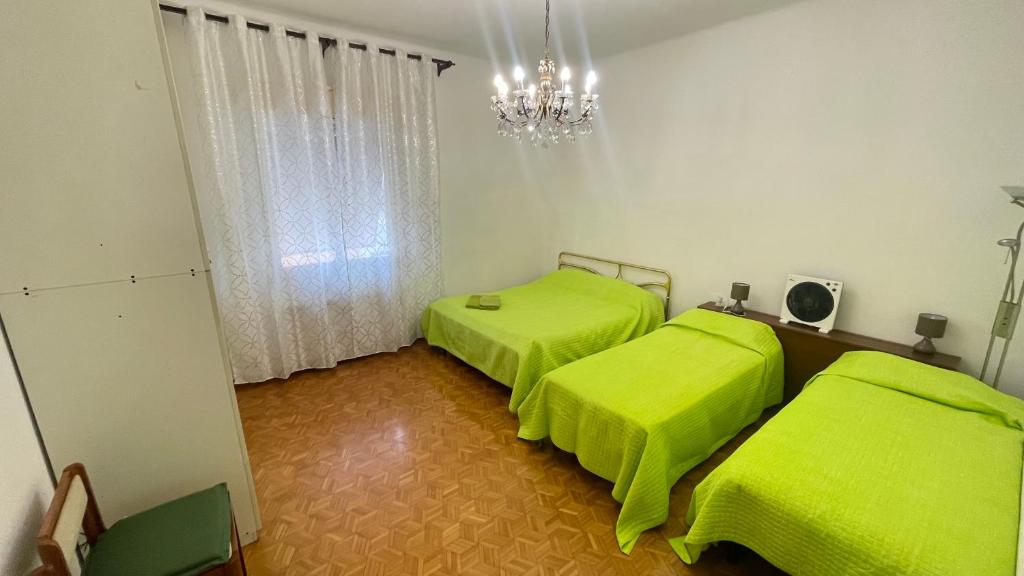 duas camas num quarto com lençóis verdes em da Lilia in Salute&Bellezza em Monfalcone