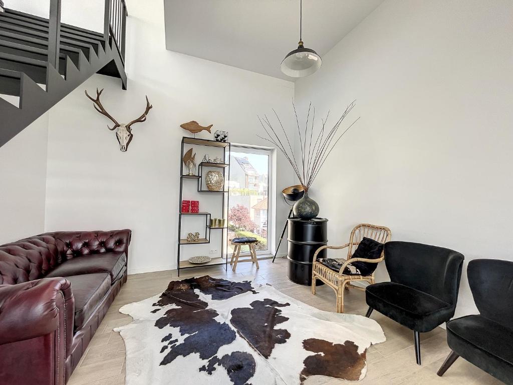 a living room with a couch and a chair at Villa SeaShell - Luxurious renovated gas station in Koksijde