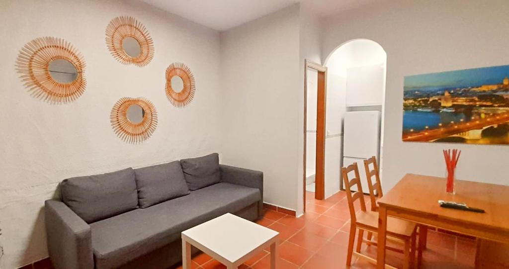een woonkamer met een bank en een tafel bij Apartamento EXCLUSIVE TRIANA - Ribera del Guadalquivir in Sevilla