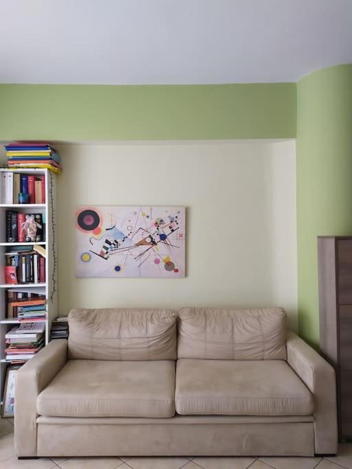 a living room with a couch and a painting on the wall at Άνετο studio σε πολυκατοικία στην Άνω Γλυφάδα in Athens