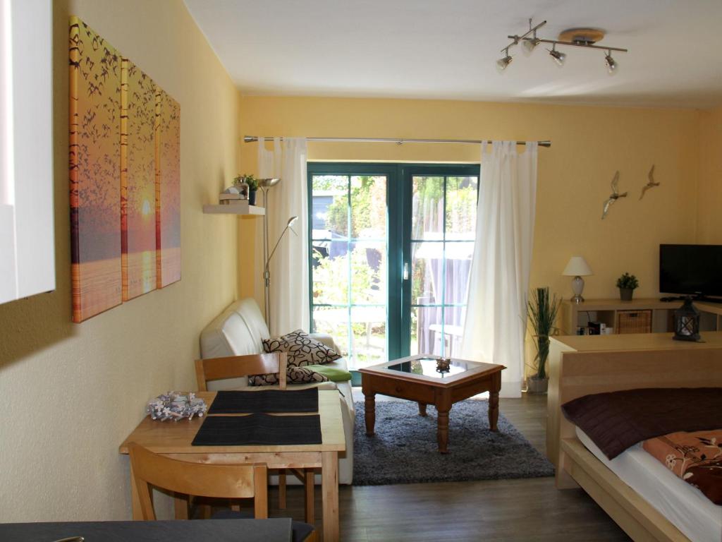 ein Schlafzimmer mit einem Bett und ein Wohnzimmer mit einem Tisch in der Unterkunft NEU! FeWo Haubentaucher 600 Meter vom Strand in Prerow