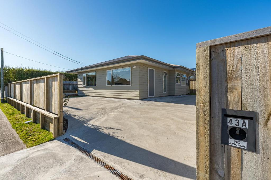 ein Haus mit einem Tor mit einem Schild darauf in der Unterkunft Cosy and Central in Taupo