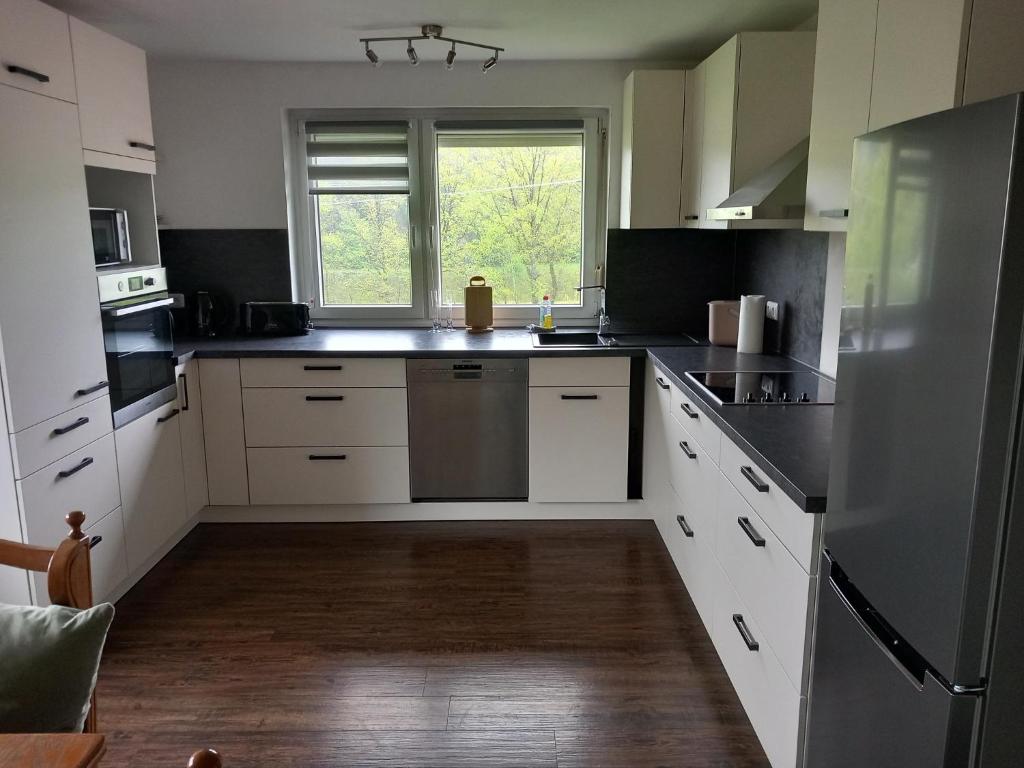 een keuken met witte apparatuur en een raam bij Ferienwohnung am Waldrand in Bechhofen