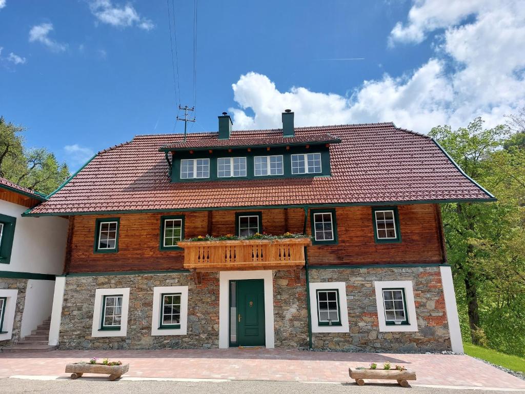 una antigua casa de ladrillo con un balcón de madera. en Landhaus Grünjuwel en Himmelberg