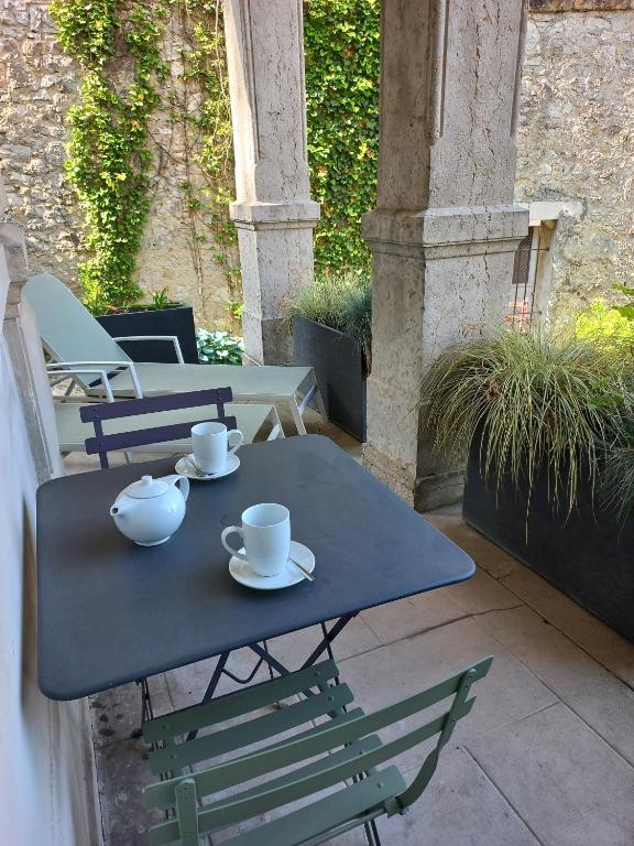 a blue table with cups and saucers on a patio at Villa Saint Enogat in Aix-les-Bains