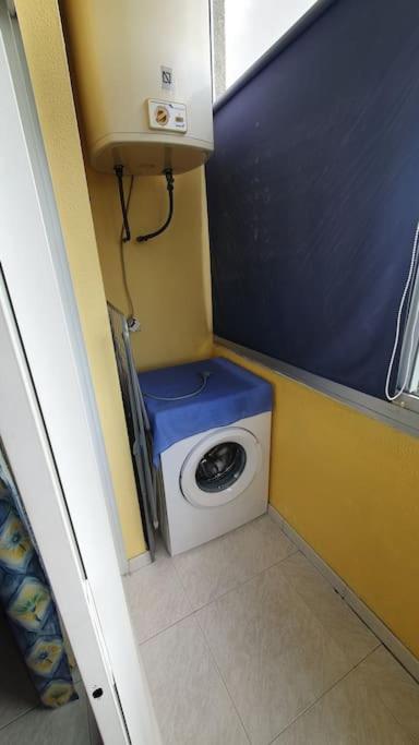 a small bathroom with a washing machine in the corner at Precioso ático en Playa América a 200 metros de la playa in Nigrán
