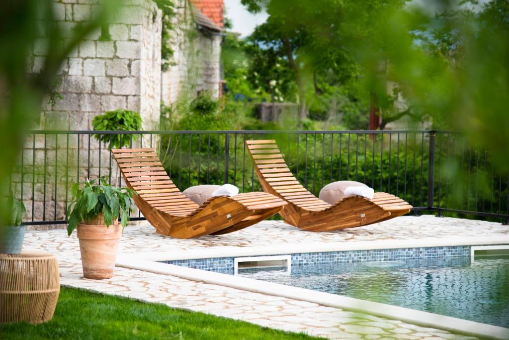 - deux chaises longues installées à côté de la piscine dans l'établissement Villa Vita, à Trilj