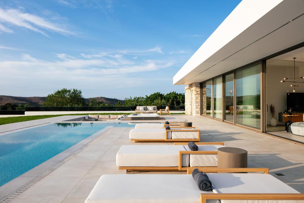une maison avec une piscine et une terrasse dans l'établissement Cresto Iconic Villa, with Heated Spa Whirlpool, By ThinkVilla, à Angeliana
