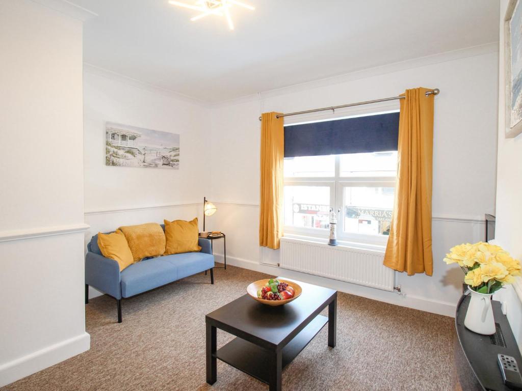 a living room with a couch and a window at Stones Throw in Weymouth