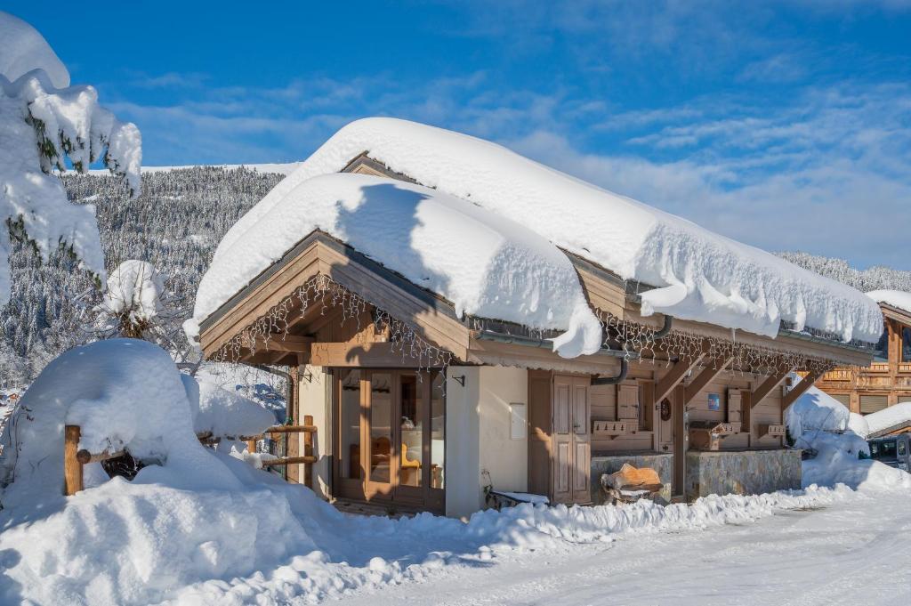 une maison recouverte de neige avec un toit recouvert de neige dans l'établissement Chalet Lunar, aux Gets