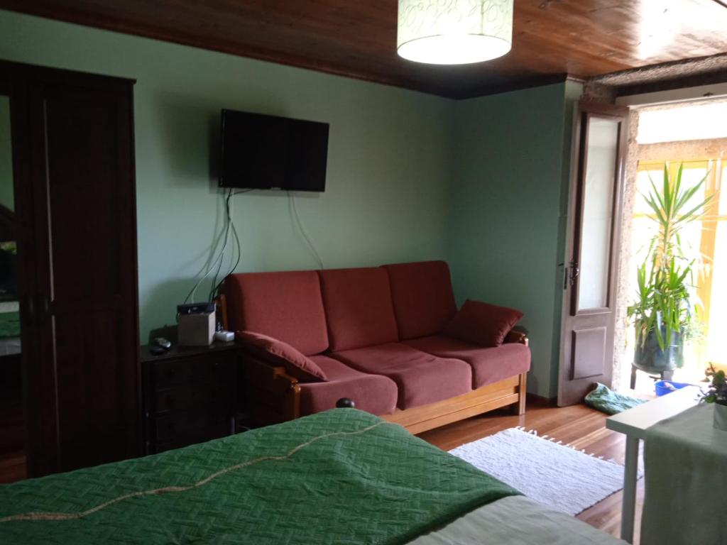 - un salon avec un canapé et une télévision murale dans l'établissement Quinta dos Campos - Apartamento 1, à Braga