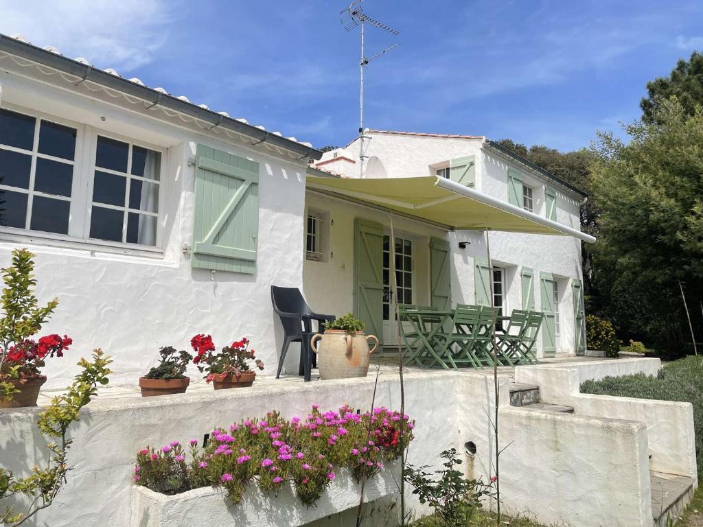 a white house with flowers on the front porch at Maison Noirmoutier-en-l'Île, 5 pièces, 8 personnes - FR-1-224B-477 in Noirmoutier-en-l'lle