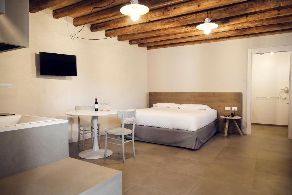 1 dormitorio con cama, mesa y TV en Borgo Gradis'ciutta, en Gorizia