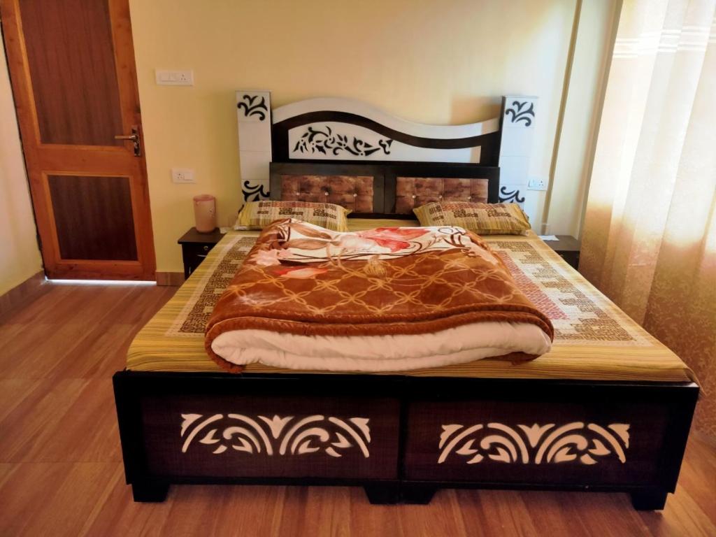 Conifers Deluxe Room في شيملا: سرير كبير في غرفة نوم مع أرضية خشبية