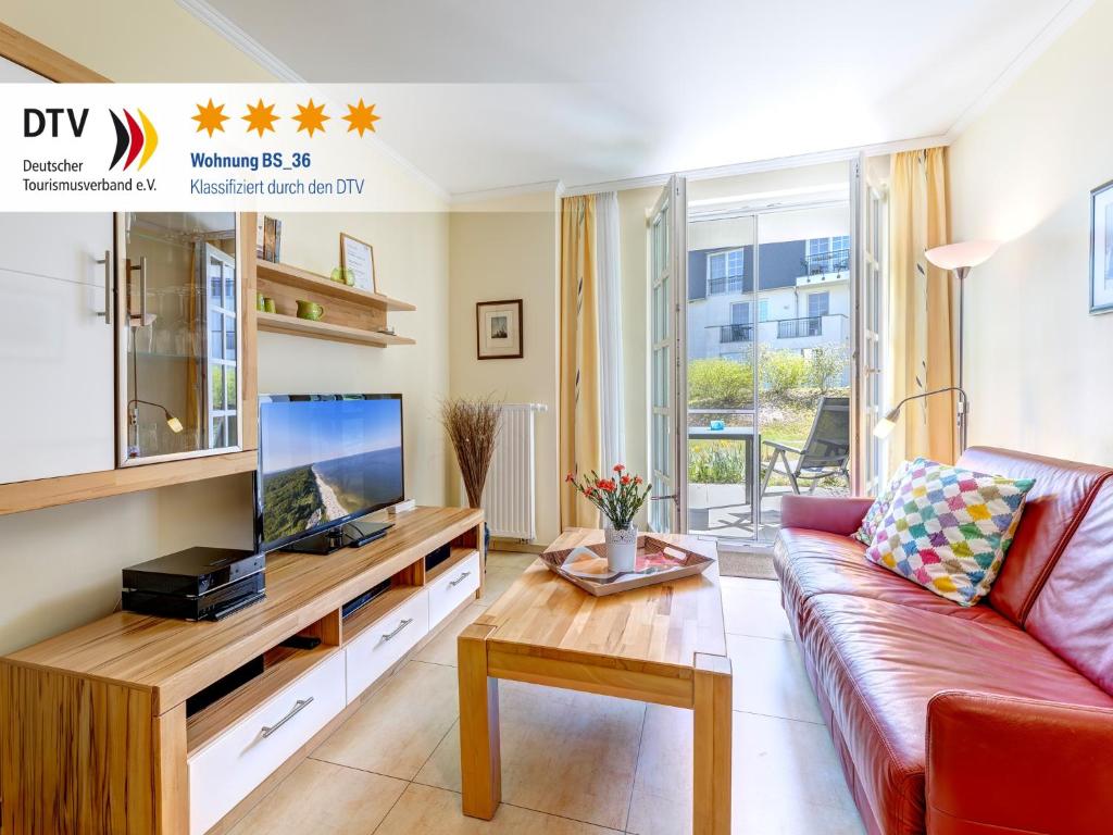 a living room with a couch and a tv at Residenz am Balmer See - BS 36 mit Wellnessbereich in Balm