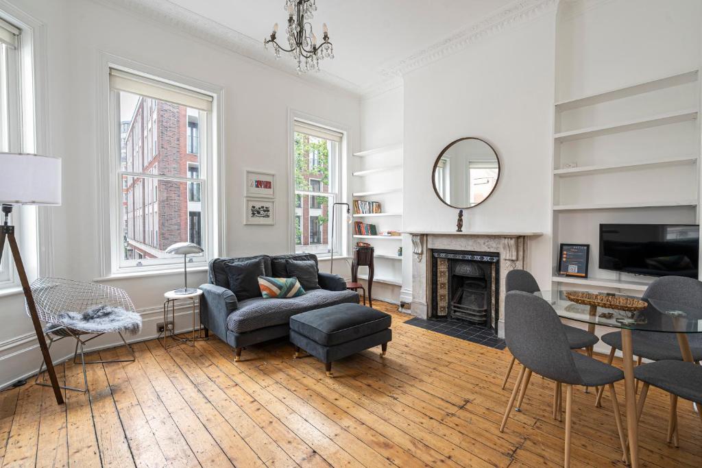 a living room with a couch and a fireplace at JOIVY Chic flat with private terrace near Kensington Palace in London