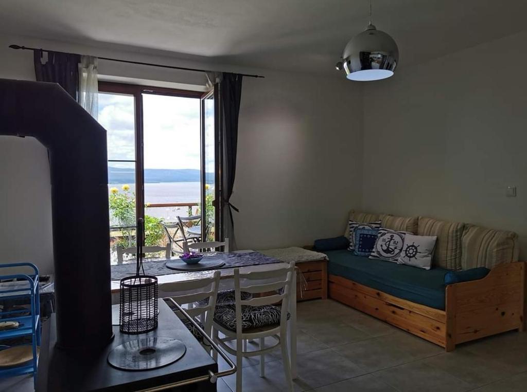 ein Wohnzimmer mit einem Bett und einem Tisch mit Aussicht in der Unterkunft Apartmán s terasou a výhledem na jezero Lipno in Kovářov