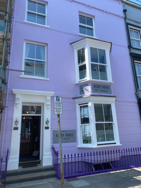 a purple house with a sign in front of it at Ashby House in Tenby
