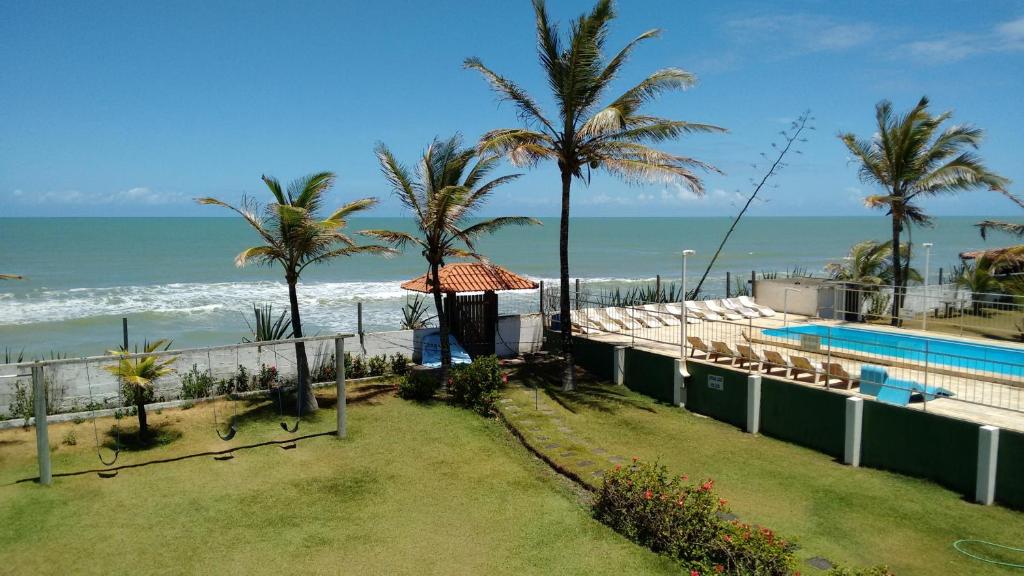 a resort with a swimming pool and the ocean at Pousada Mirante in Conceição da Barra