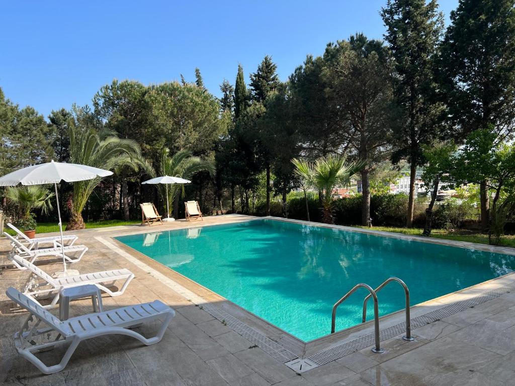 a swimming pool with two chairs and an umbrella at Özel Havuzlu Bahçeli Müstakil Villa in Şile