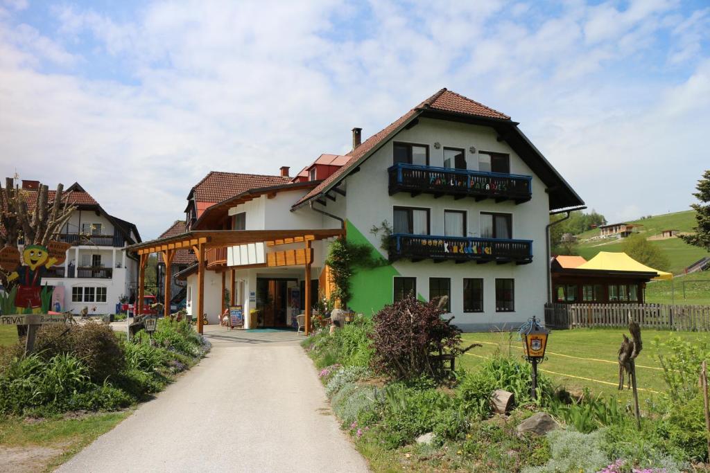 une grande maison blanche avec un chemin dans l'établissement Familienparadies Reichenhauser, à Keutschach am See