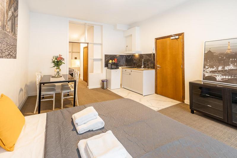 een woonkamer met een groot bed en een keuken bij Paile gare du Nord in Brussel