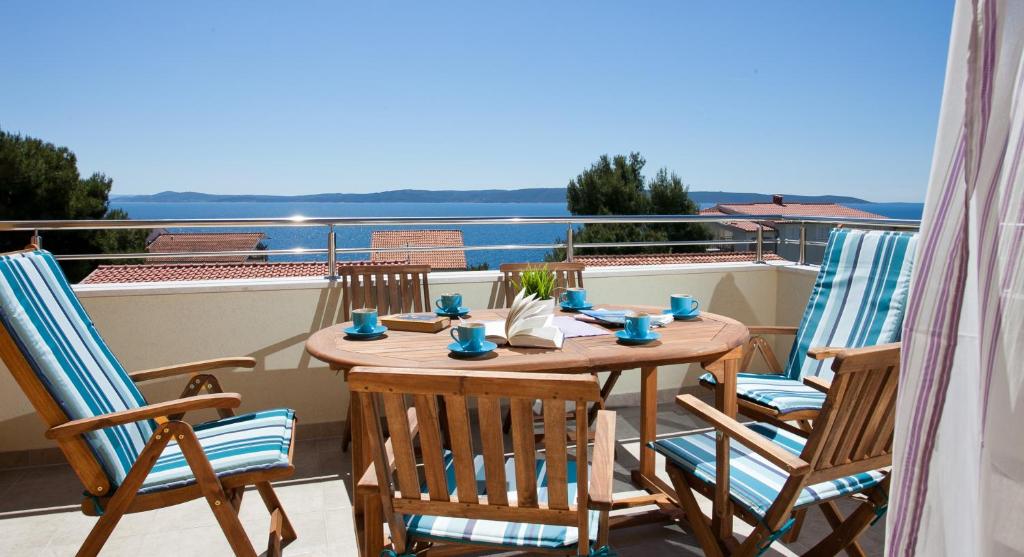 a table and chairs on a balcony with a view at Apartments Medvid in Trogir