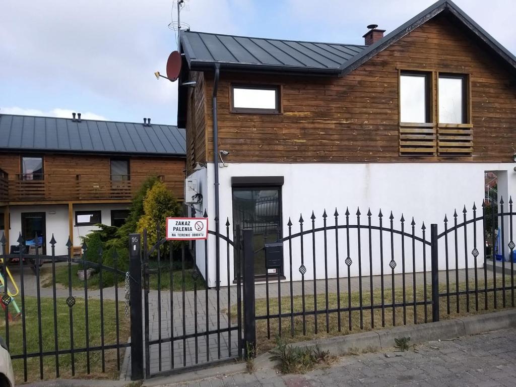a house with a fence and a no parking sign at Dom Apart Magda Rewal in Rewal