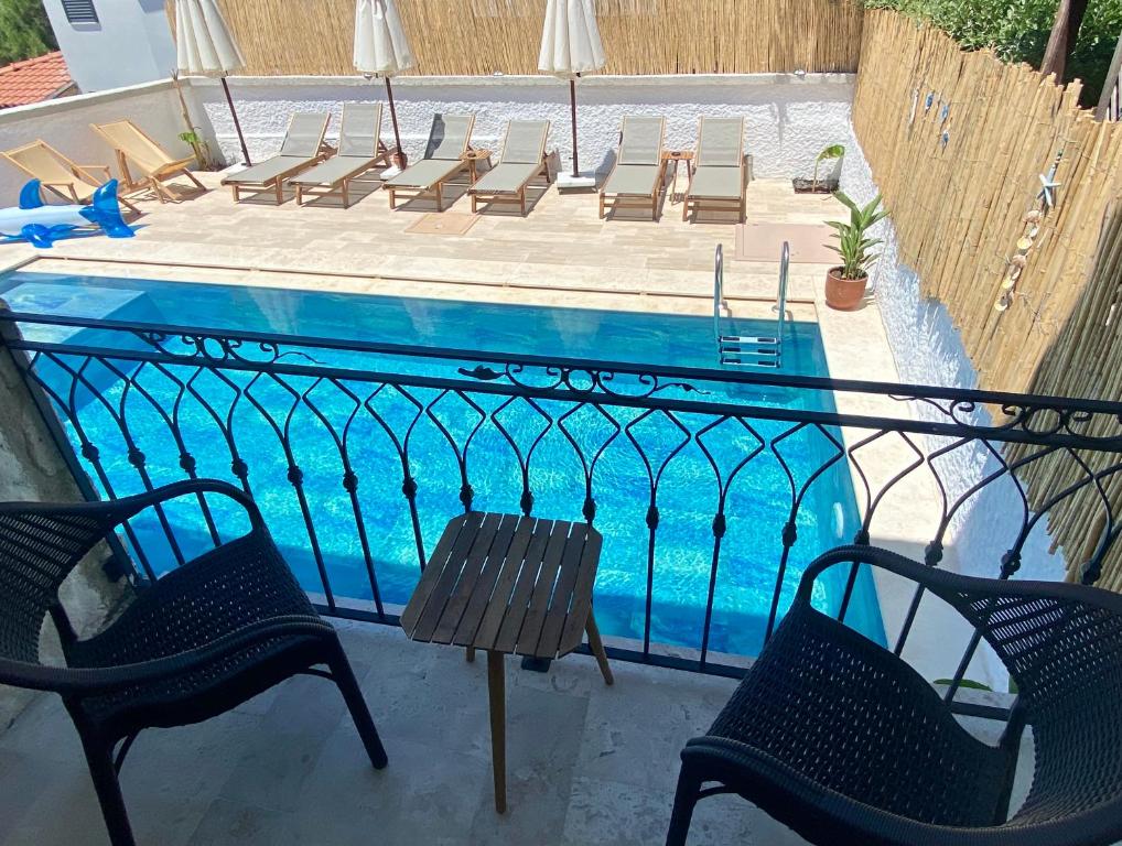 een zwembad met stoelen en een tafel en twee stoelen bij Serez Otel Alaçatı by La Mira in Ildır