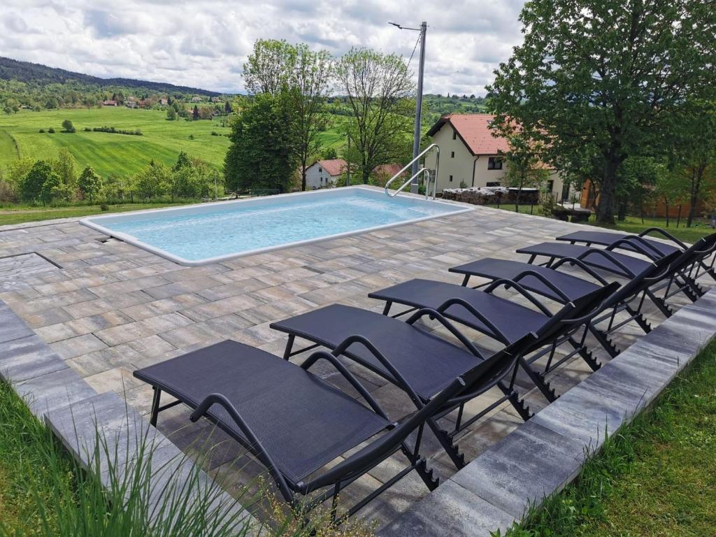 un gruppo di sedie a sdraio accanto alla piscina di Apartment Iko a Rakovica