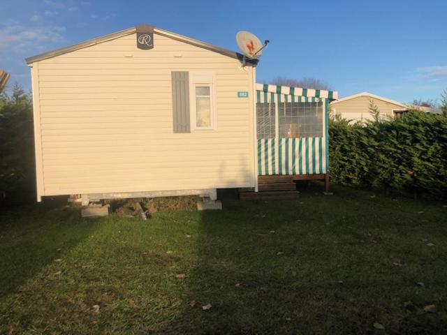 a small house in a yard with a fence at mobilhome 582 Les Charmettes 3ch tout équipé in Les Mathes