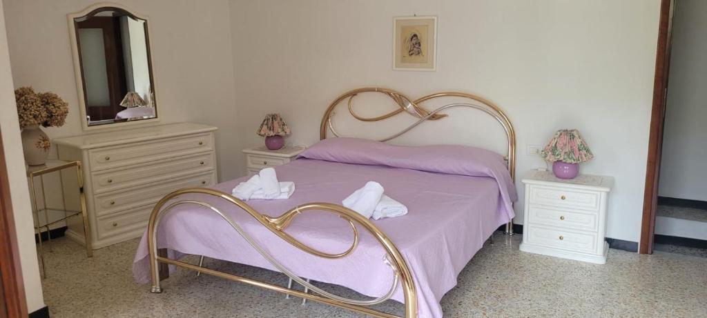 una camera da letto con un letto con lenzuola viola e uno specchio di Affittacamere L'Arco a Volastra