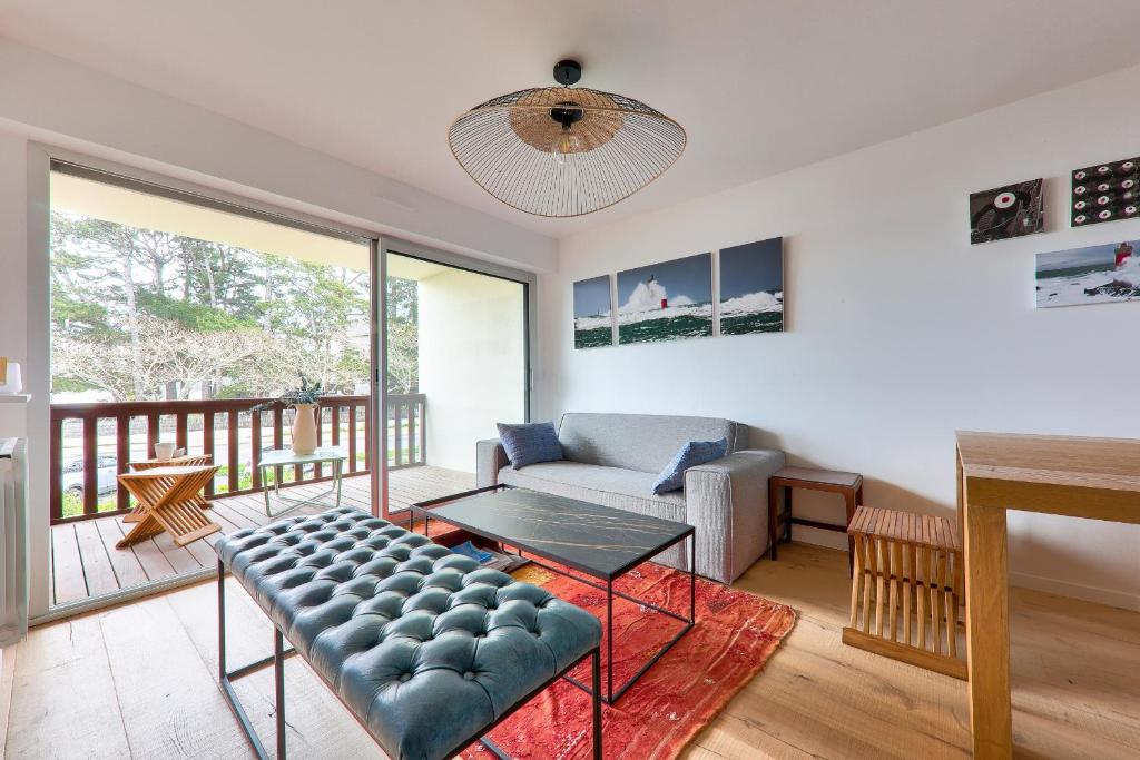 una sala de estar con un sofá y una mesa en Vue mer à Carnac, Duplex pour 8, en Carnac