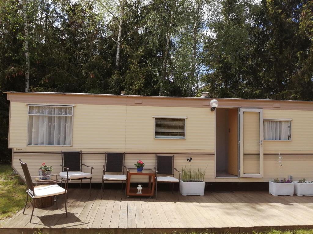 een tiny house met een veranda en een terras bij Domek holenderski in Moryń