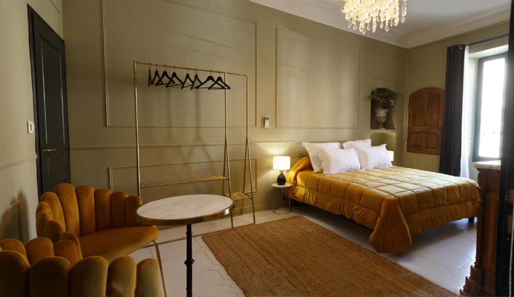 a bedroom with a bed and a table and a chair at Le 215 Gambetta boutique hôtel en Provence in Cavaillon