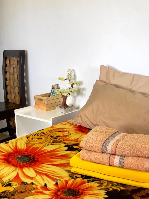 a bed with a pile of towels on it at Andrew & Mary's Lodging House in Sagada