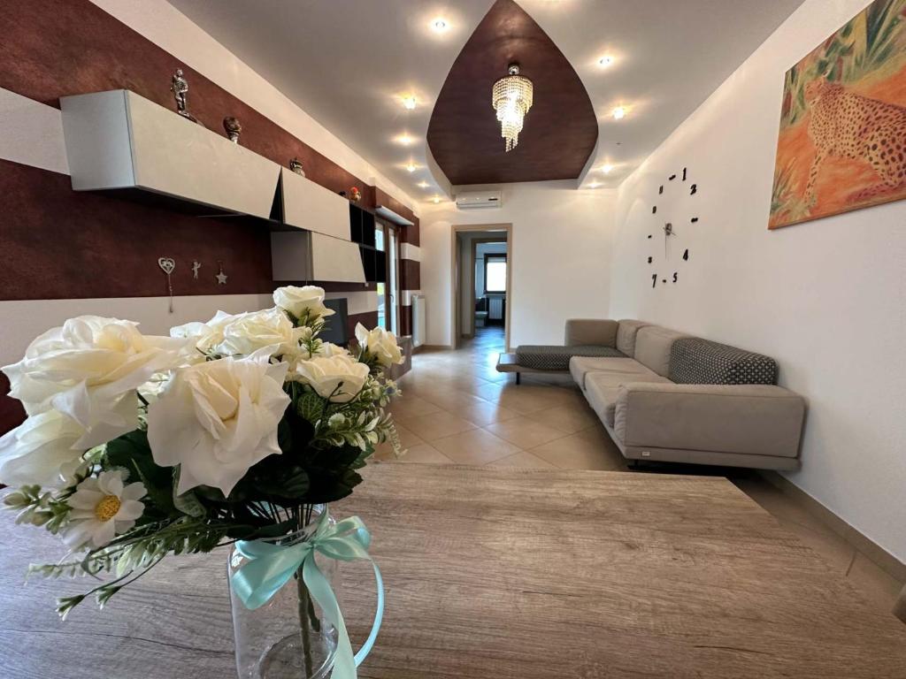 una sala de estar con un jarrón lleno de flores blancas en Machiavelli Apartment Meravigliosa Puglia Real Estate, en Carovigno