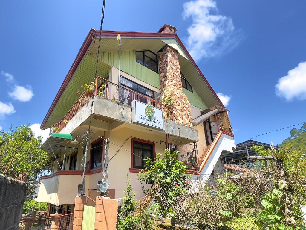 a tall building with a balcony on top of it at Andrew & Mary's Lodging House in Sagada