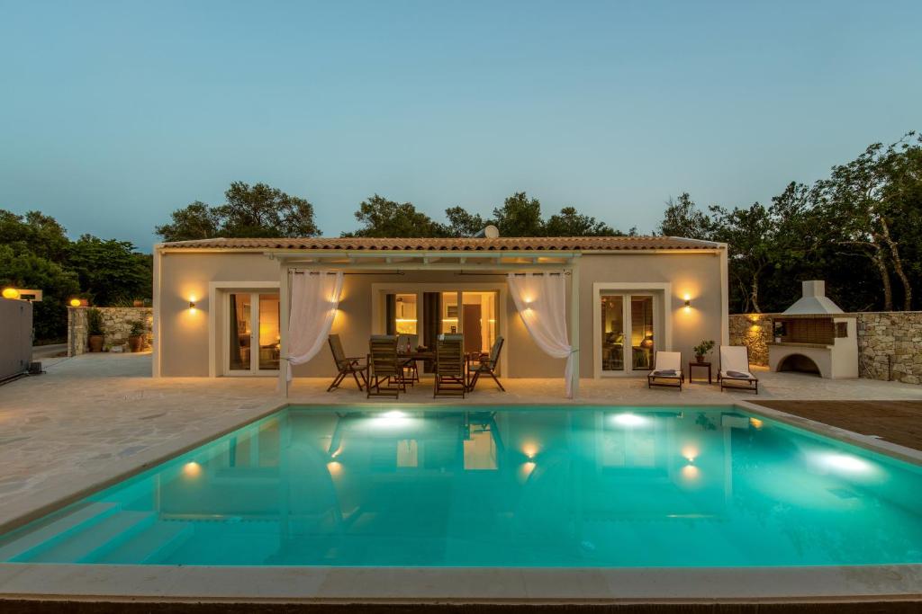 a swimming pool in front of a house at Villa Irida in Plátanos