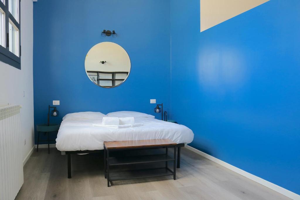 Habitación azul con cama y espejo en Smart and Comfy Apartment - Via Repubblica di San Marino, en Milán