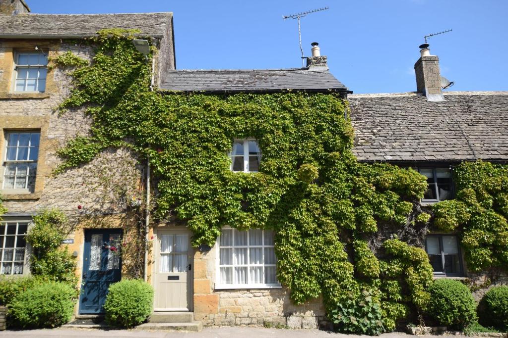 an ivy covered house in the village at Honey Cottage in Stow on the Wold