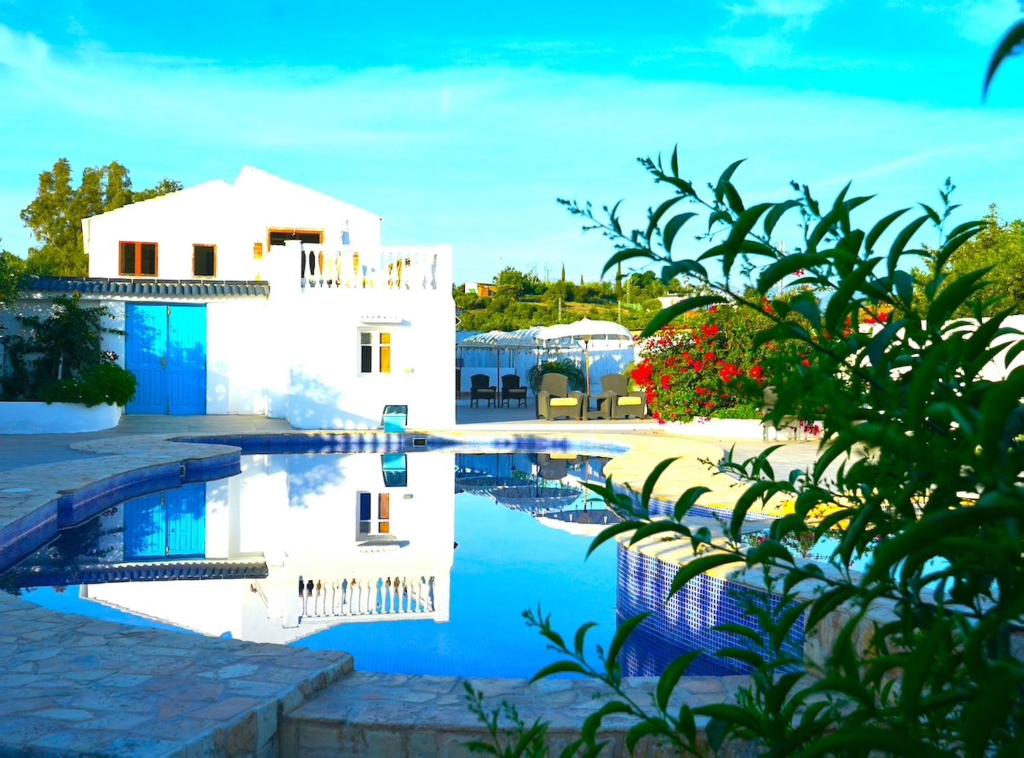 a villa with a swimming pool in front of a house at Enchanting Retreat Your Private Haven in Coín
