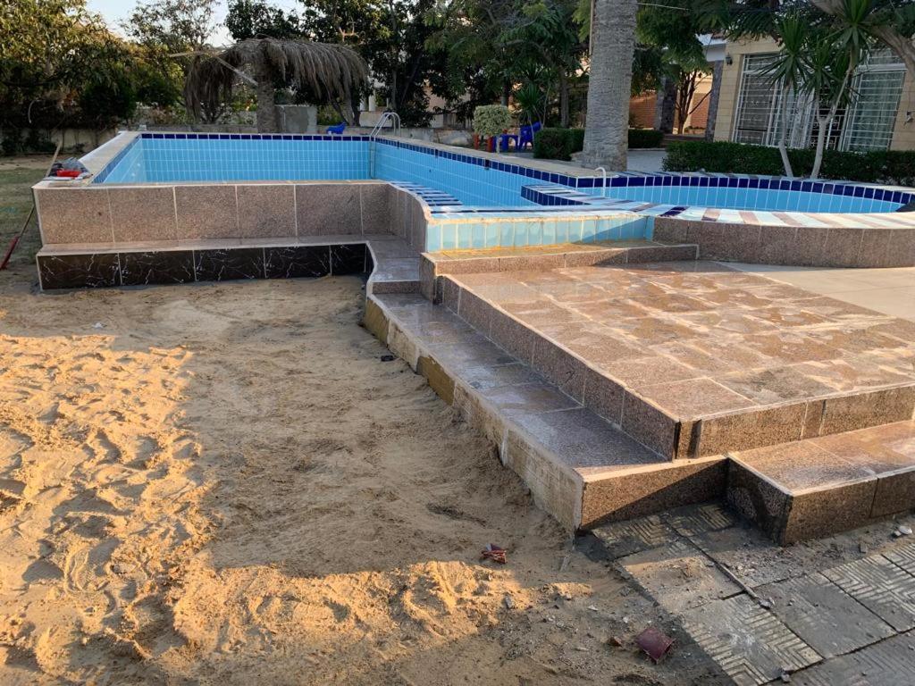 a swimming pool with steps in the sand next to it at Villa amir in Sarābiyūm