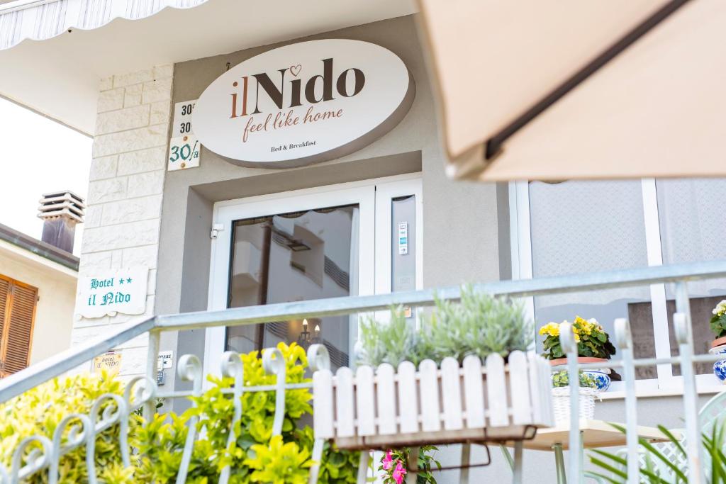 een restaurant met een bord dat indio bemest gazon bij Hotel Il Nido in Rimini