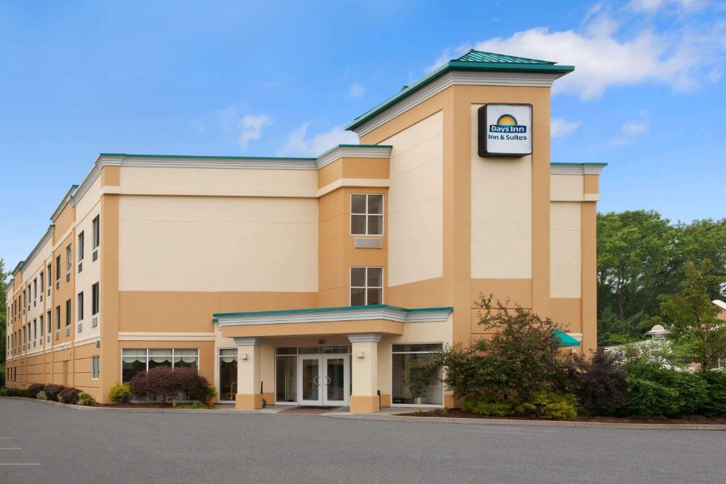 a large office building with a sign on it at Days Inn & Suites by Wyndham Albany in Albany