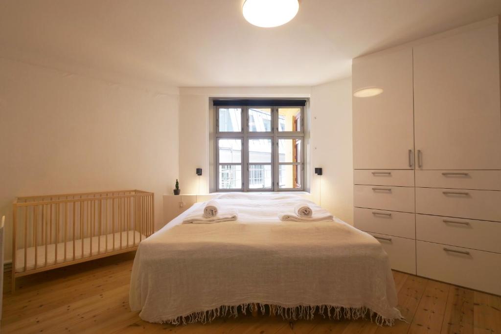 a white bedroom with a bed and a window at Central apartment - RAP 7 in Copenhagen