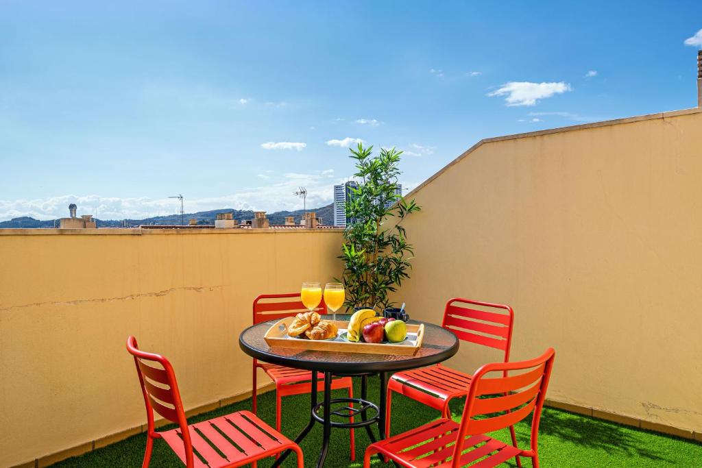 a table and chairs with a bowl of fruit on a balcony at Heart Location & PARKING in Málaga