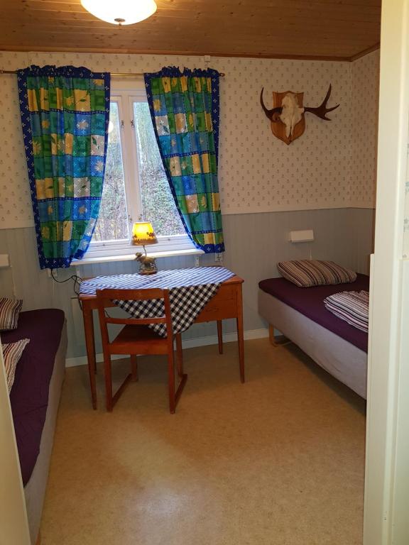 a room with a table and a bed and a window at Ammeråns Fiskecamp 